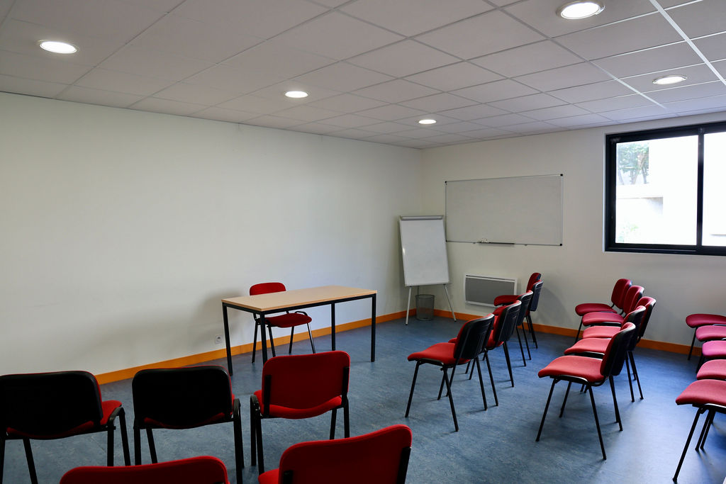 Salle Belle-Île avec tables, chaises et tableaux blancs pour les réunions
